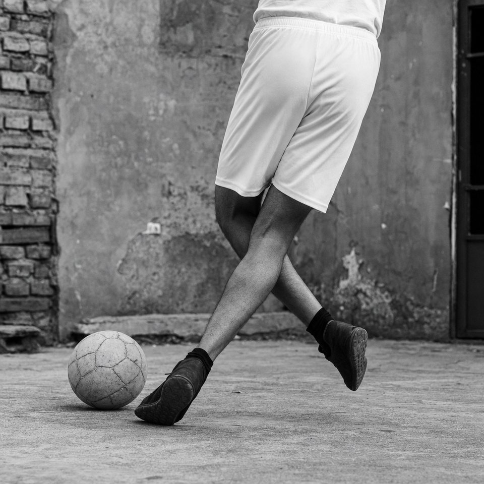 Vista lateral de una rabona: la pierna ejecutora cruza por detrás de la de apoyo para llegar a la pelota del lado contrario